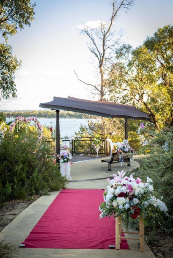 Riverside gazebo ceremony with red carpet aisle