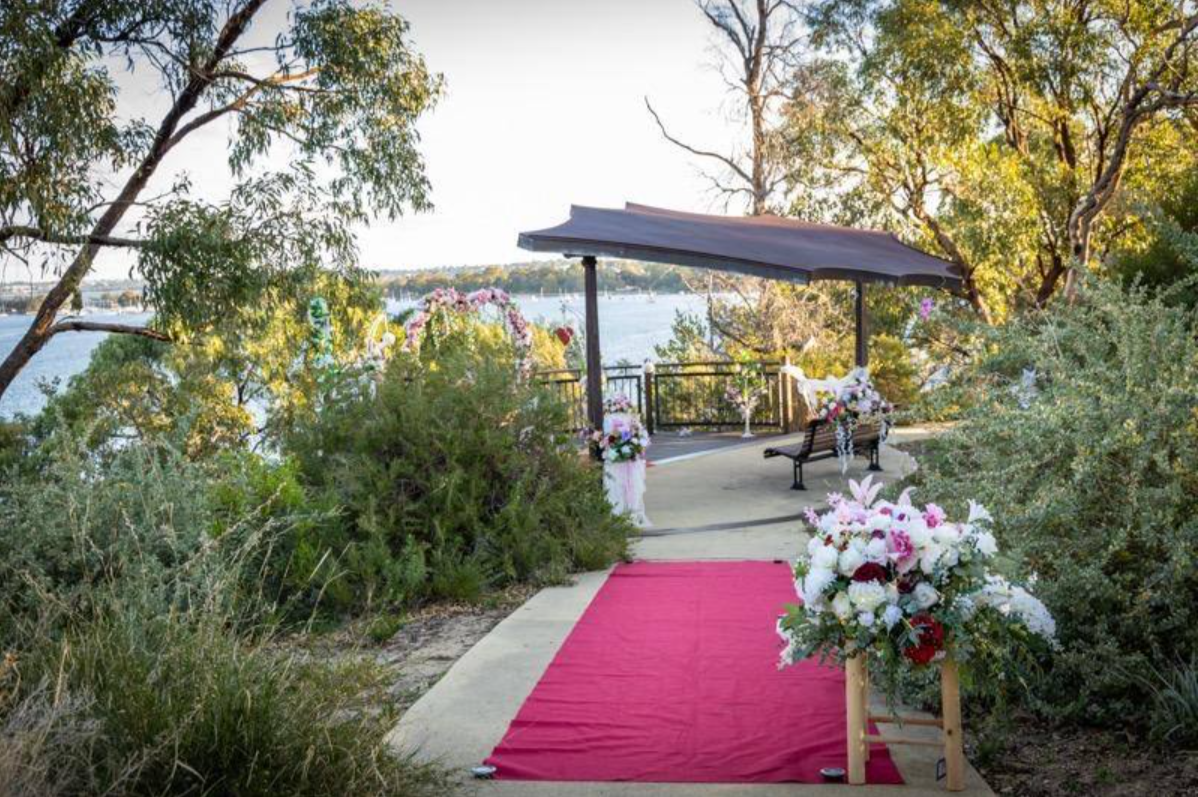 Twin floral arches framing a riverside gazebo